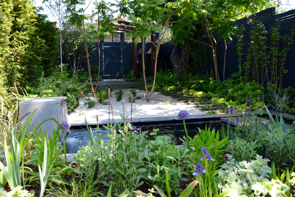 Inspiration for a medium sized contemporary back partial sun garden for summer in London with a pond.