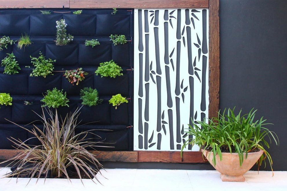 Diseño de jardín contemporáneo de tamaño medio en patio trasero con jardín vertical, exposición parcial al sol y adoquines de hormigón