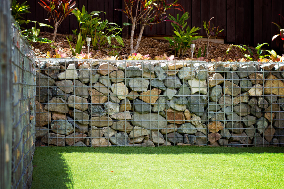 Inspiration pour un jardin arrière minimaliste de taille moyenne avec un mur de soutènement et une exposition partiellement ombragée.