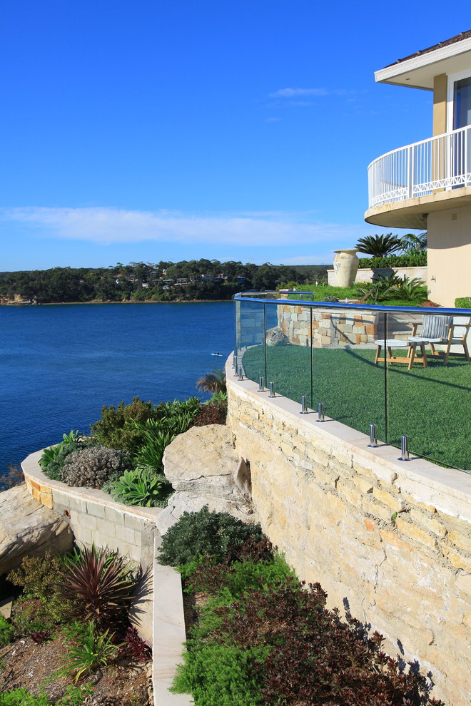 Foto di un giardino costiero esposto in pieno sole di medie dimensioni con un muro di contenimento, un pendio, una collina o una riva e pavimentazioni in pietra naturale