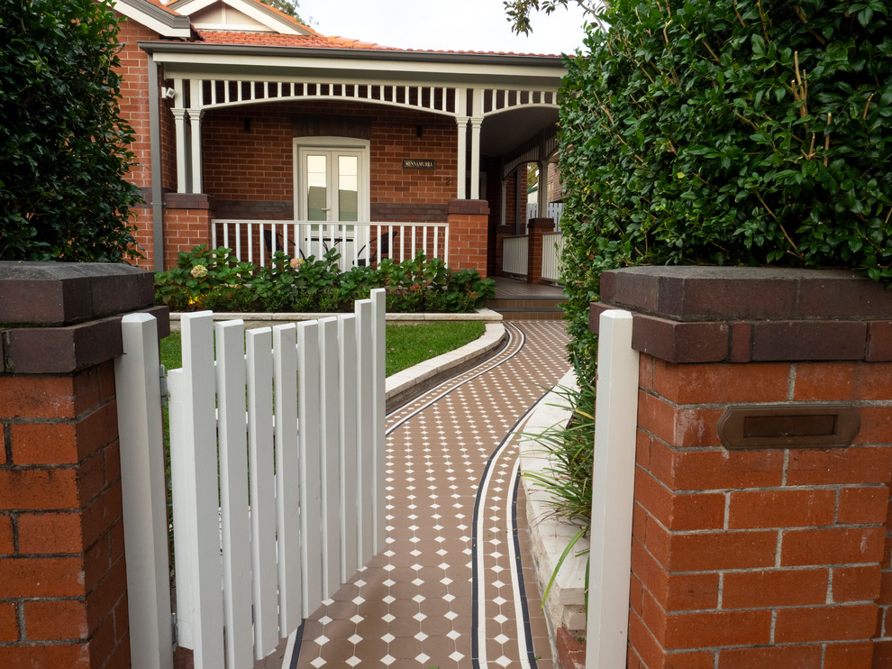 Esempio di un piccolo giardino formale tradizionale esposto a mezz'ombra davanti casa con un ingresso o sentiero e pavimentazioni in pietra naturale