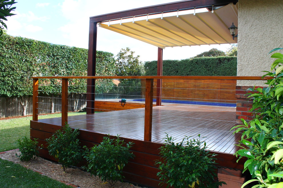 Réalisation d'un grand jardin à la française arrière tradition avec une terrasse en bois.