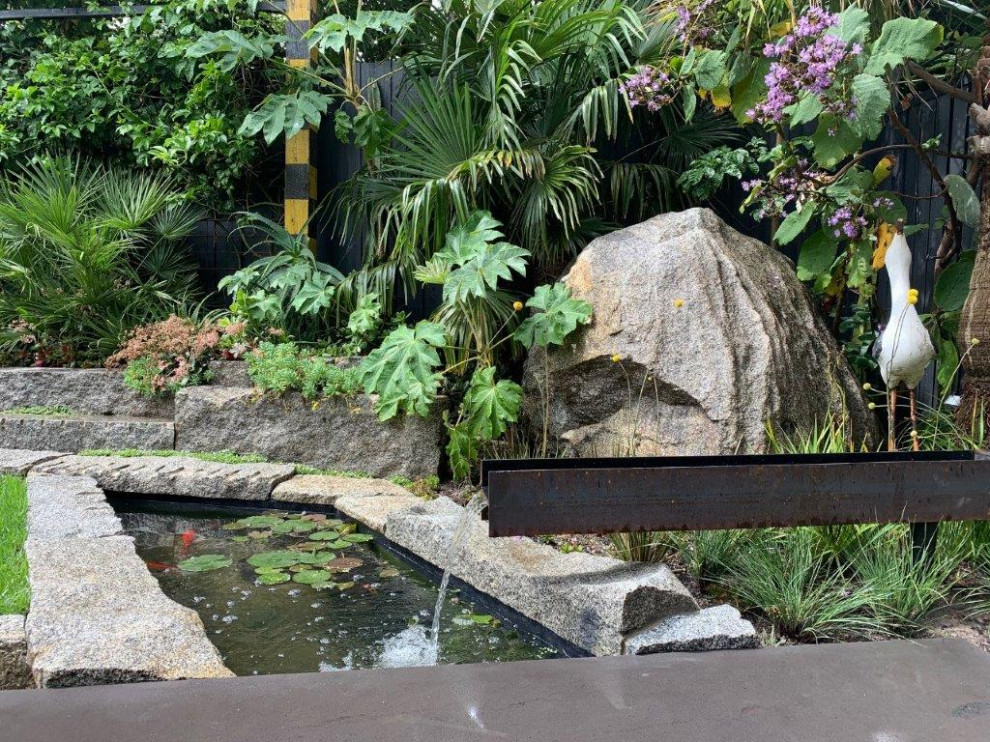 Photo of a mid-sized mid-century modern drought-tolerant and full sun backyard stone pond in Melbourne for winter.
