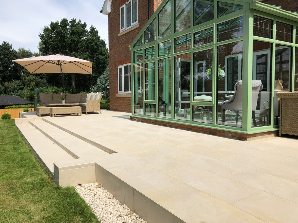 This is an example of a large contemporary back garden in Surrey.