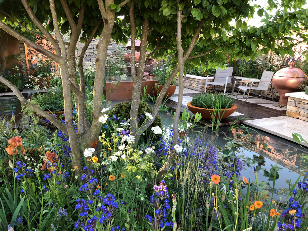 Cette image montre un jardin à la française arrière minimaliste de taille moyenne et l'été avec un bassin, une exposition ensoleillée et des pavés en pierre naturelle.