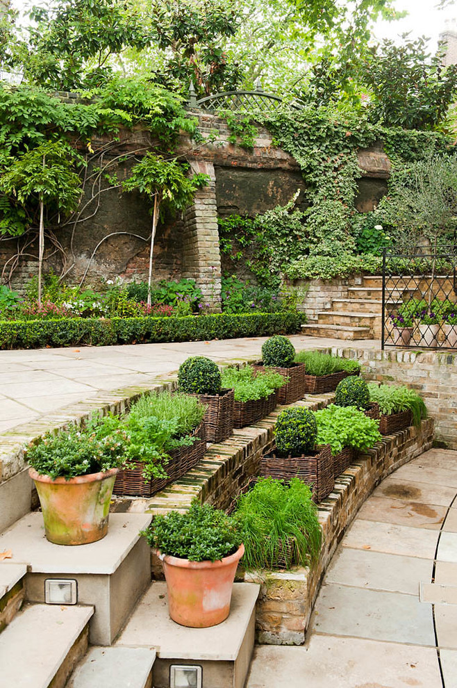 Imagen de jardín tradicional grande en primavera en patio con jardín vertical, exposición parcial al sol y adoquines de piedra natural