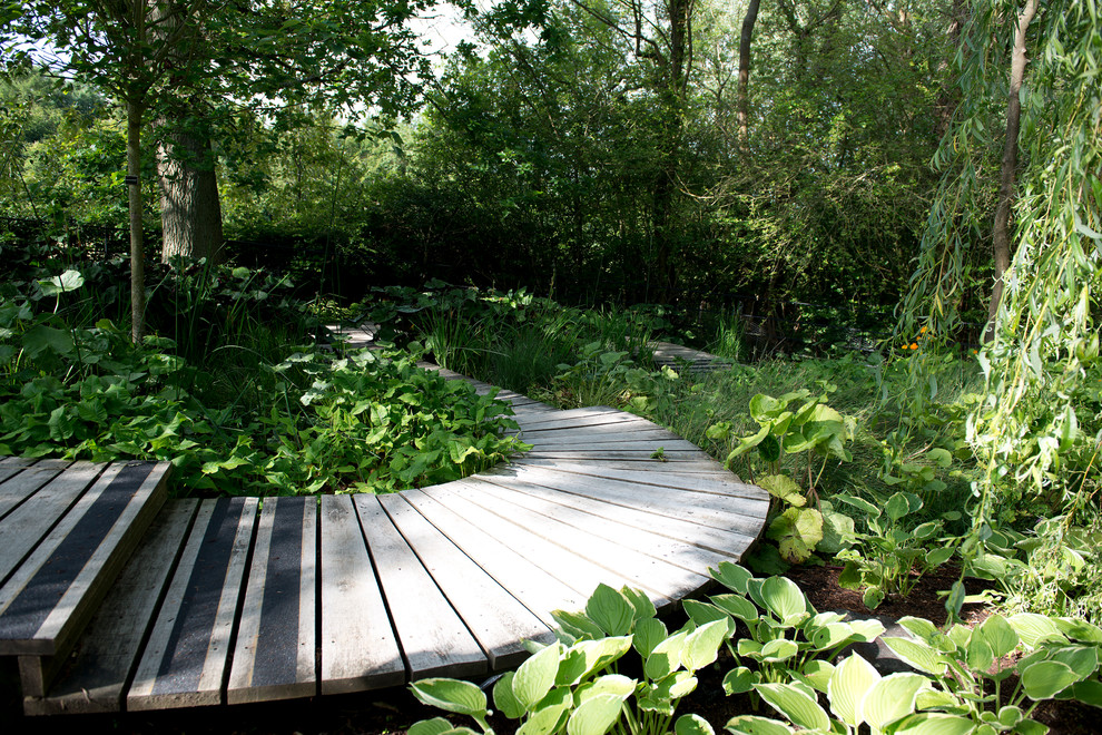 Foto di un ampio giardino country esposto a mezz'ombra dietro casa in estate con un ingresso o sentiero e pedane