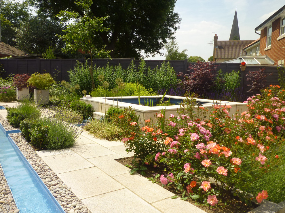 Aménagement d'un jardin contemporain de taille moyenne avec un point d'eau et des pavés en pierre naturelle.