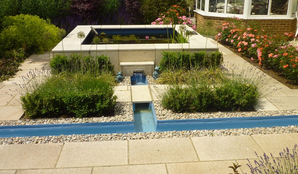 Cette photo montre un jardin tendance de taille moyenne avec un point d'eau et des pavés en pierre naturelle.