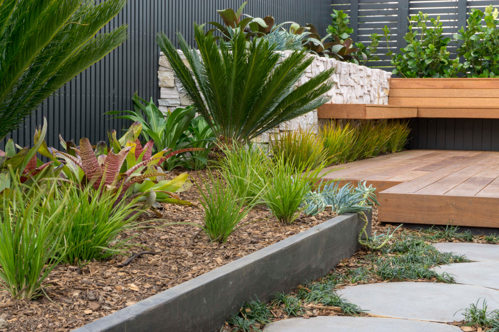 Esempio di un grande giardino contemporaneo esposto in pieno sole dietro casa con pedane e recinzione in legno