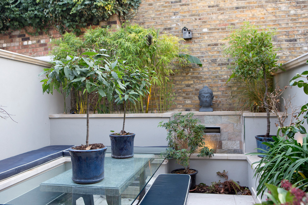 Idee per un piccolo giardino minimal dietro casa con pavimentazioni in pietra naturale