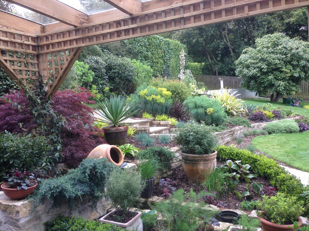 Modelo de jardín clásico grande en otoño en patio trasero con jardín de macetas, jardín francés, exposición reducida al sol y mantillo