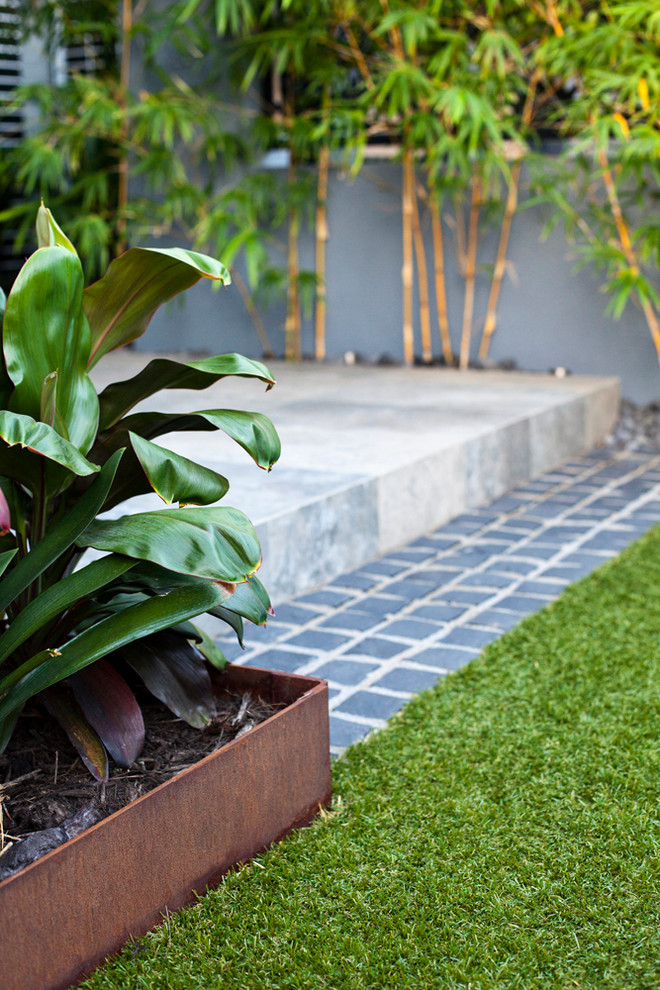 Esempio di un giardino formale contemporaneo esposto in pieno sole di medie dimensioni e dietro casa con pavimentazioni in pietra naturale