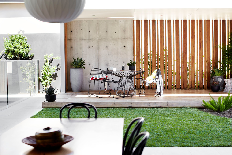 シドニーにあるラグジュアリーな中くらいな、夏のコンテンポラリースタイルのおしゃれな中庭 (擁壁、半日向、デッキ材舗装) の写真