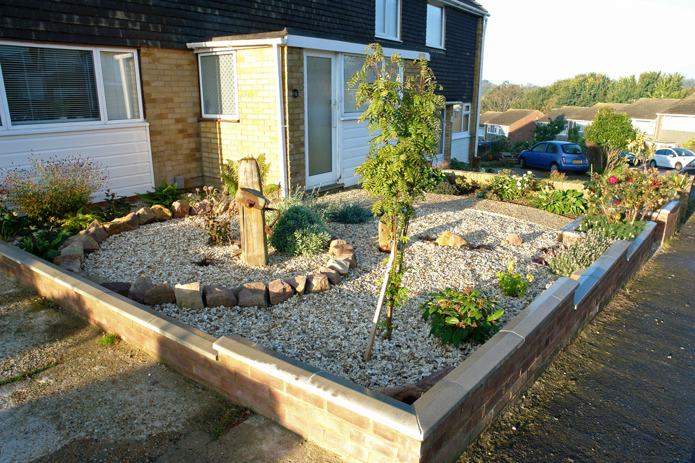 This is an example of a medium sized coastal front xeriscape partial sun garden for spring in Sussex with gravel.