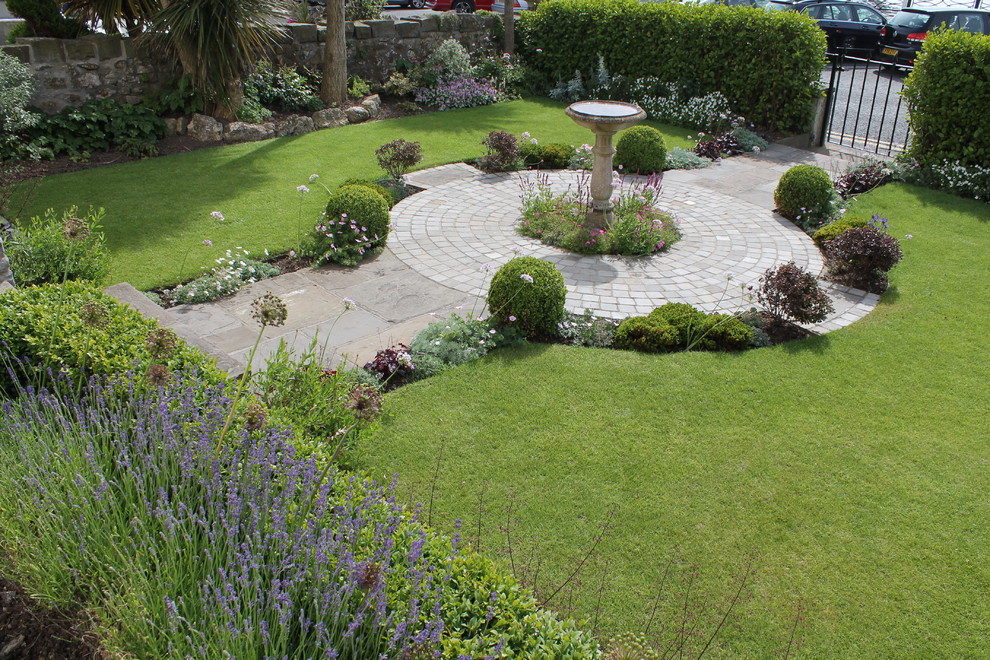 Aménagement d'un jardin avant bord de mer de taille moyenne et l'été avec une exposition ensoleillée et des pavés en pierre naturelle.