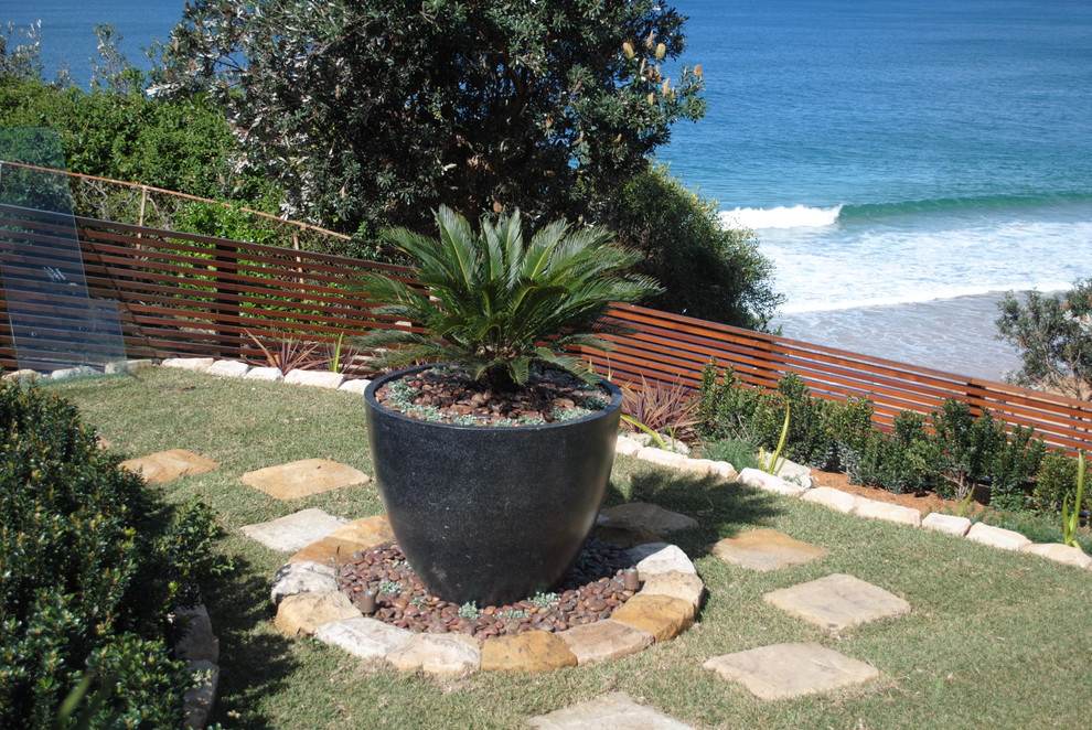 Пример оригинального дизайна: летний регулярный сад среднего размера на заднем дворе в современном стиле с полуденной тенью, настилом и подпорной стенкой