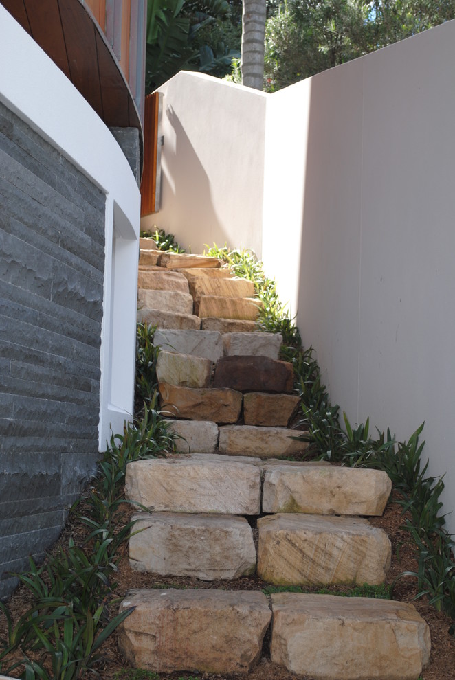 Пример оригинального дизайна: летний регулярный сад среднего размера на заднем дворе в современном стиле с полуденной тенью, подпорной стенкой и покрытием из каменной брусчатки