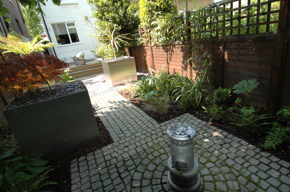 Modelo de jardín clásico pequeño en patio trasero con jardín francés, jardín de macetas, exposición reducida al sol y adoquines de hormigón