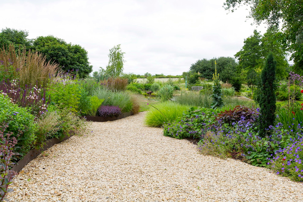 Inspiration for a large back garden for summer in Oxfordshire with gravel and a raised bed.