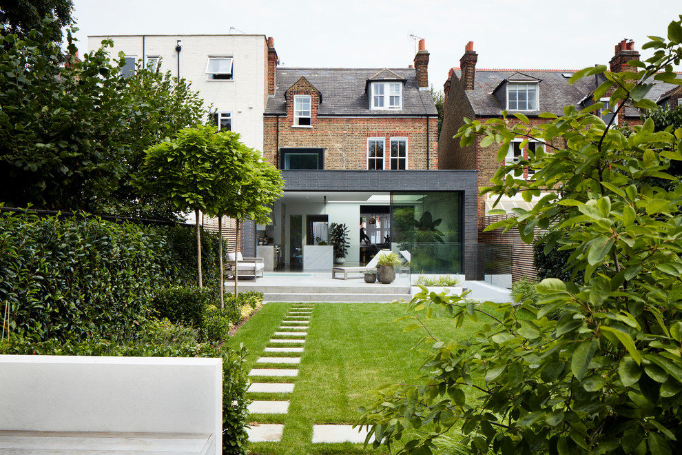 Geometrischer Moderner Garten hinter dem Haus mit direkter Sonneneinstrahlung und Betonboden in London