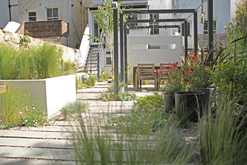 Mittelgroßer Moderner Kiesgarten hinter dem Haus mit Hochbeet und direkter Sonneneinstrahlung in Sussex
