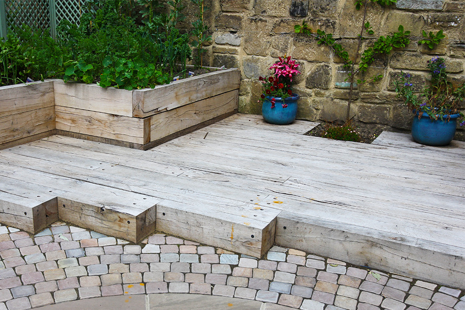 Réalisation d'un petit jardin potager arrière design l'été avec des pavés en pierre naturelle.