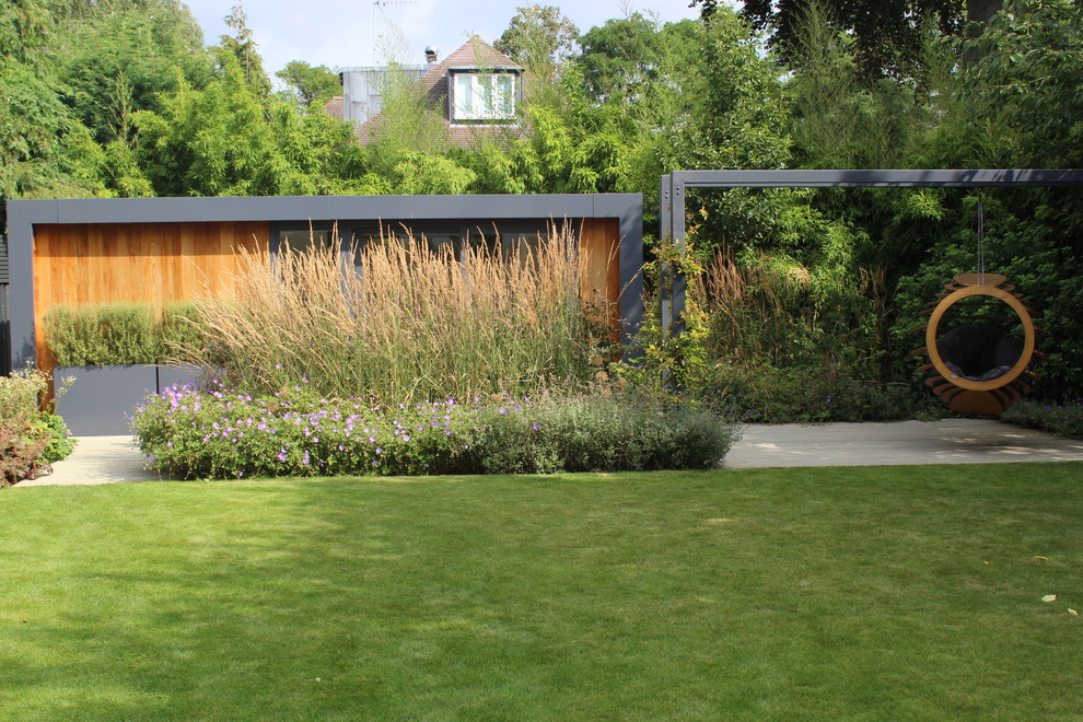 Diseño de jardín contemporáneo de tamaño medio en verano en patio trasero con jardín francés, brasero, exposición parcial al sol y entablado