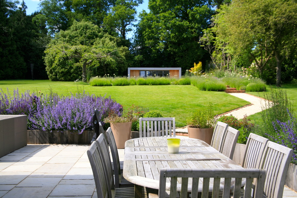 Ejemplo de jardín contemporáneo grande en verano en patio trasero con jardín francés, fuente, exposición parcial al sol y adoquines de piedra natural