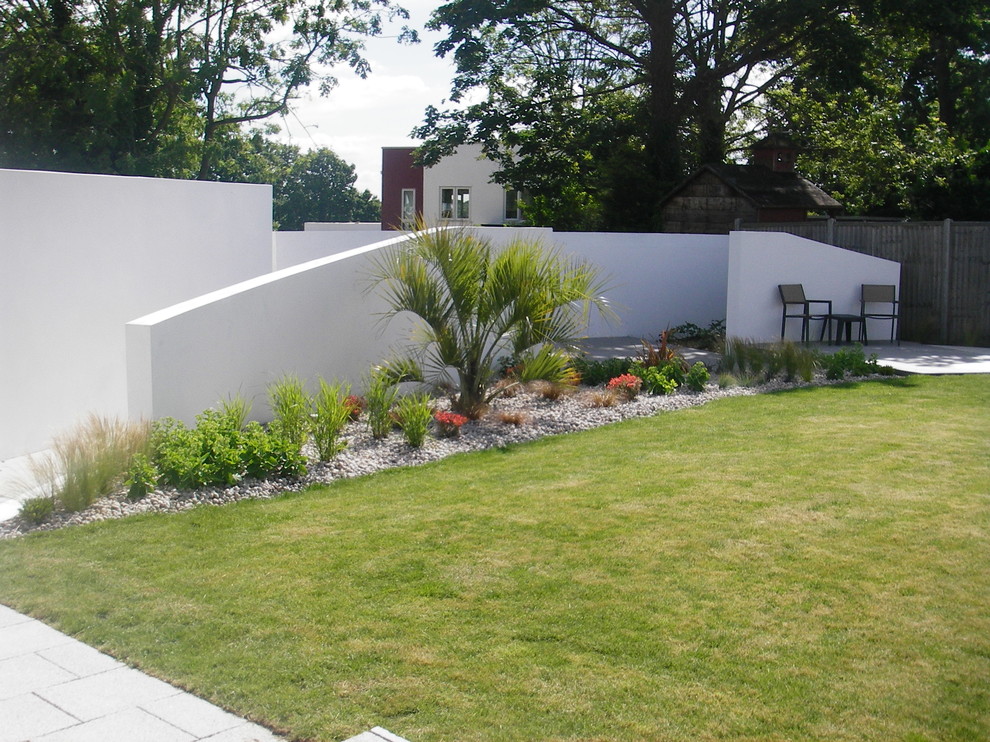 Immagine di un giardino design esposto in pieno sole dietro casa e di medie dimensioni con pavimentazioni in pietra naturale
