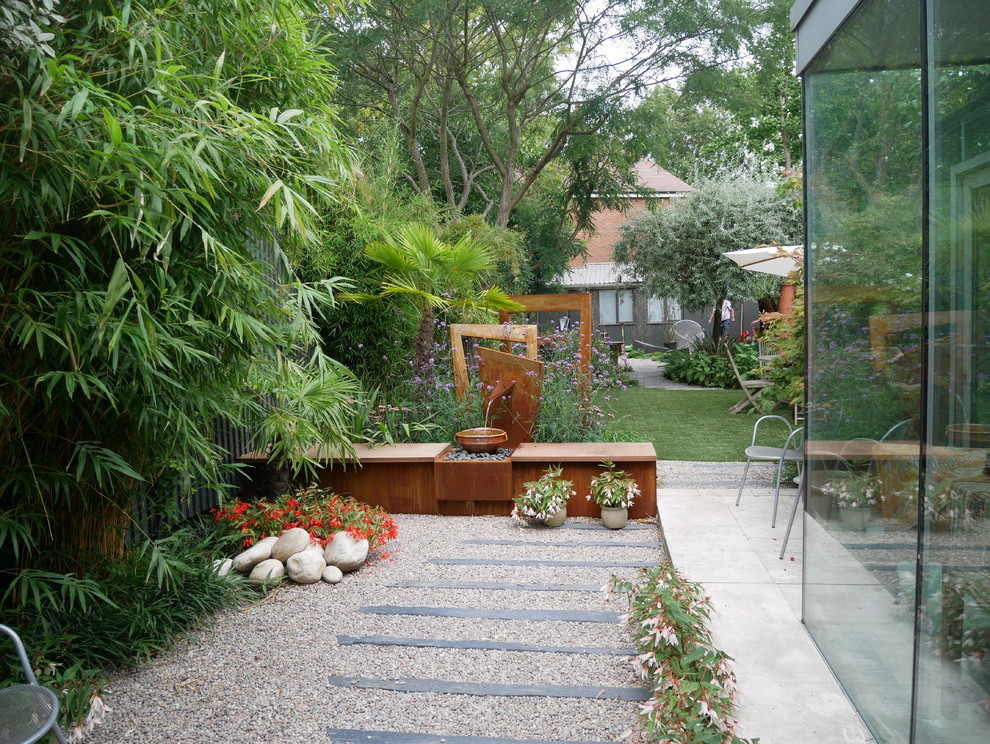 Inspiration for a contemporary garden in London with a water feature and gravel.
