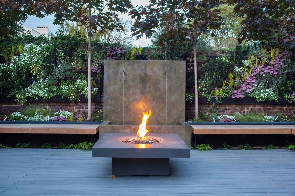 Medium sized contemporary back garden in Hampshire with a fire feature and decking.