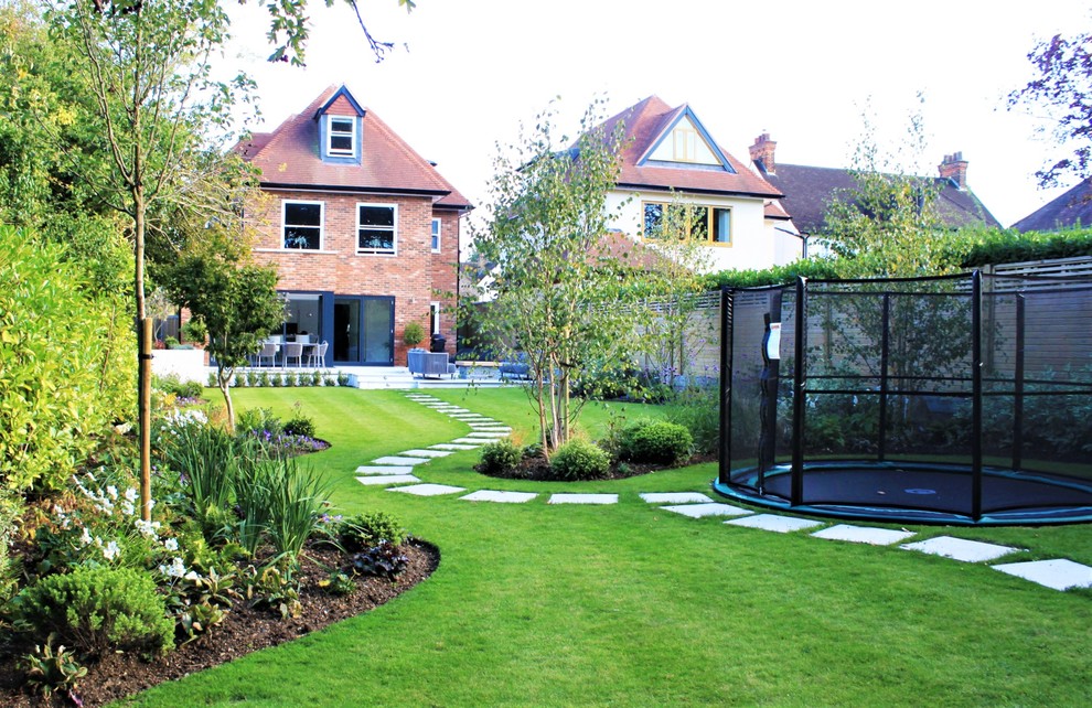 Exemple d'un grand jardin arrière tendance avec des pavés en pierre naturelle.