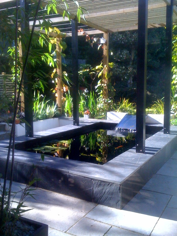 Esempio di un grande giardino formale design esposto a mezz'ombra dietro casa in estate con fontane e pavimentazioni in pietra naturale