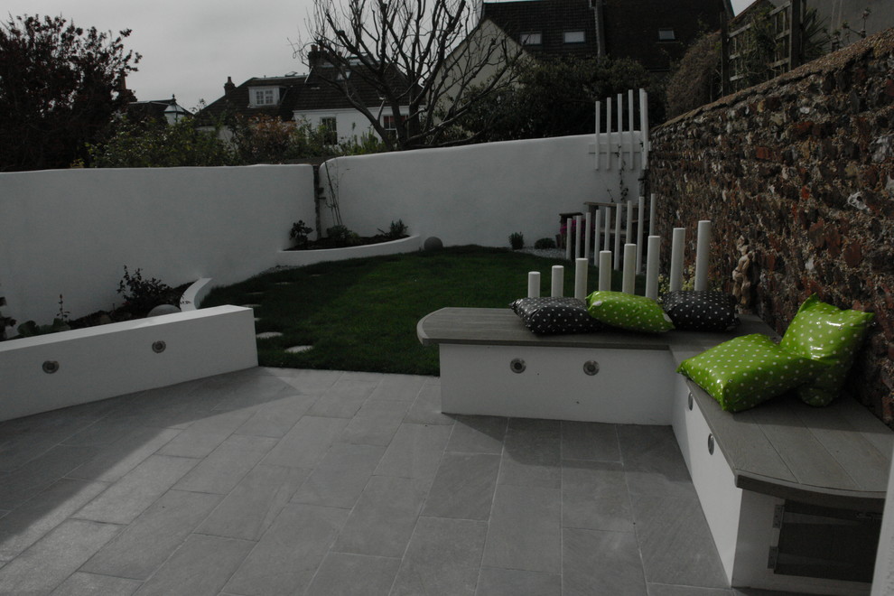 Inspiration för små moderna trädgårdar i skuggan framför huset, med en trädgårdsgång och naturstensplattor