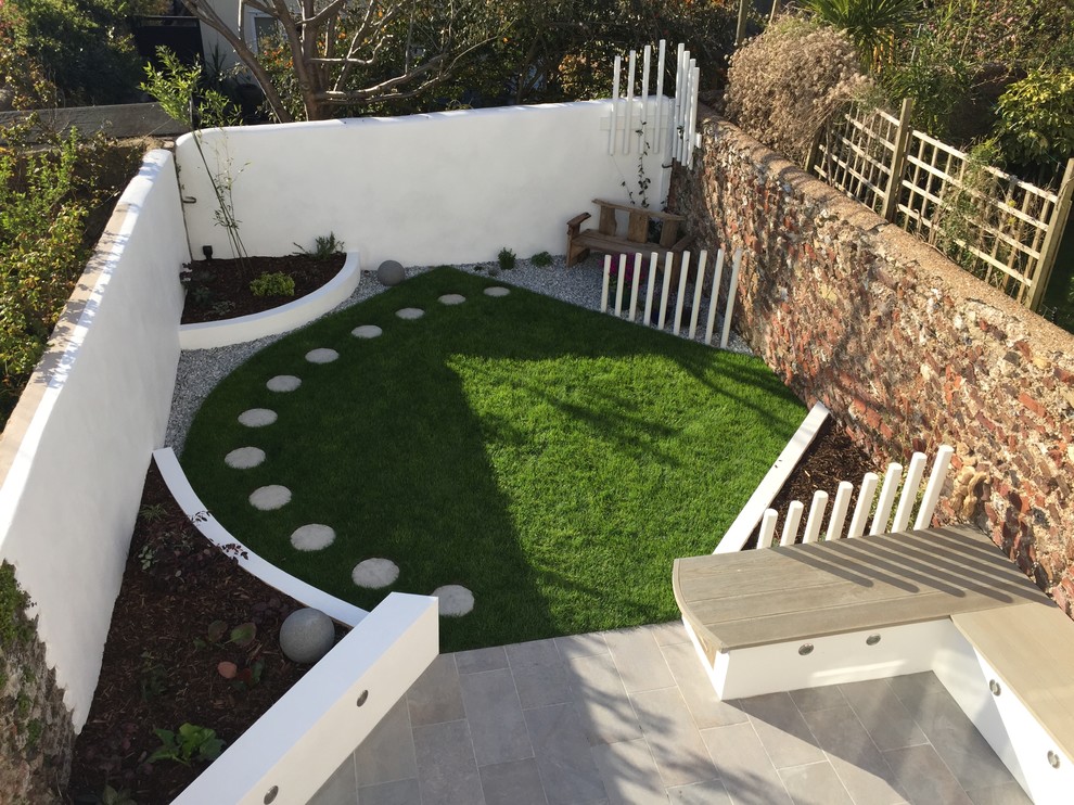 Inspiration for a small contemporary front fully shaded garden in Sussex with a garden path and natural stone paving.