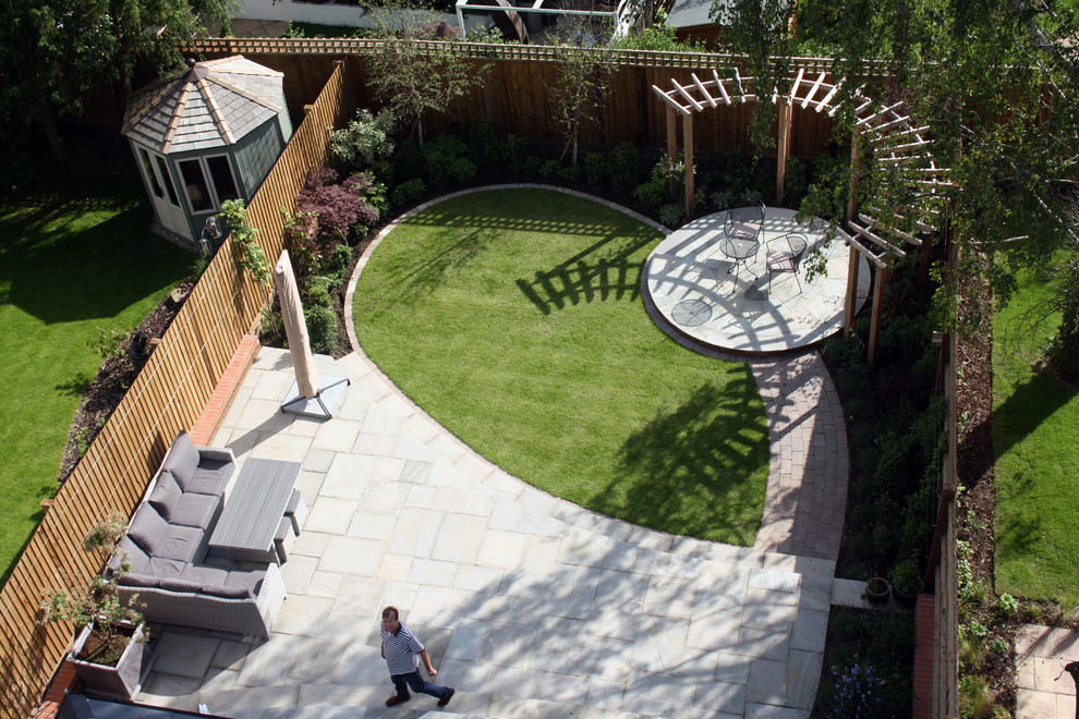 This is an example of a mid-sized contemporary full sun backyard stone landscaping in Hertfordshire for summer.