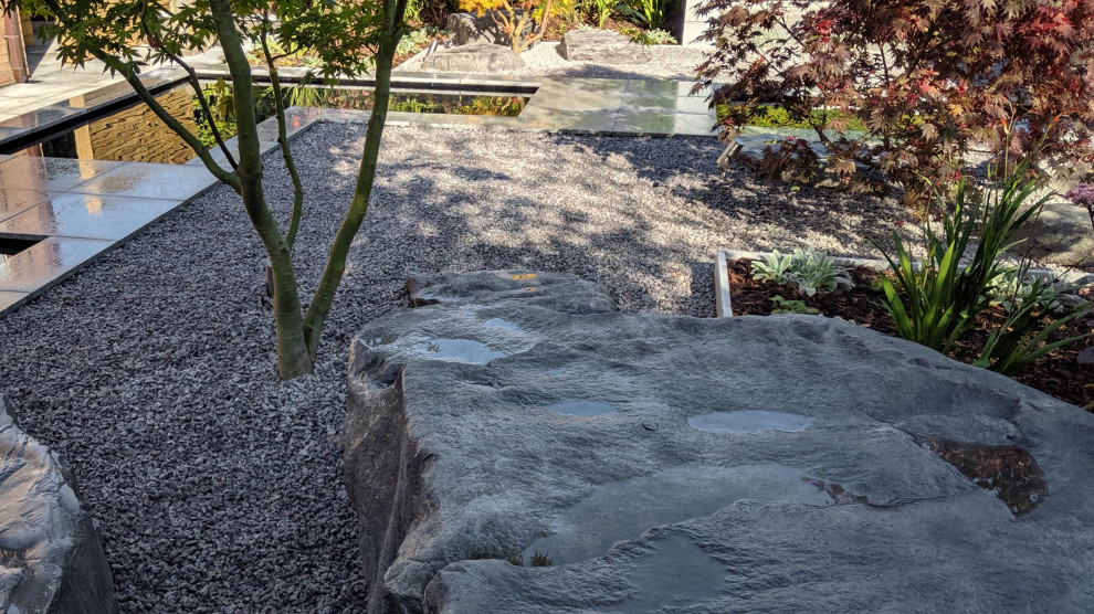 На фото: регулярный сад среднего размера на заднем дворе в современном стиле с водопадом