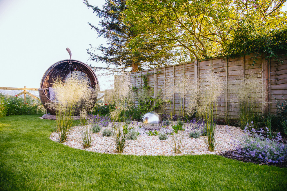 Design ideas for a mid-sized contemporary full sun backyard gravel landscaping in Other.