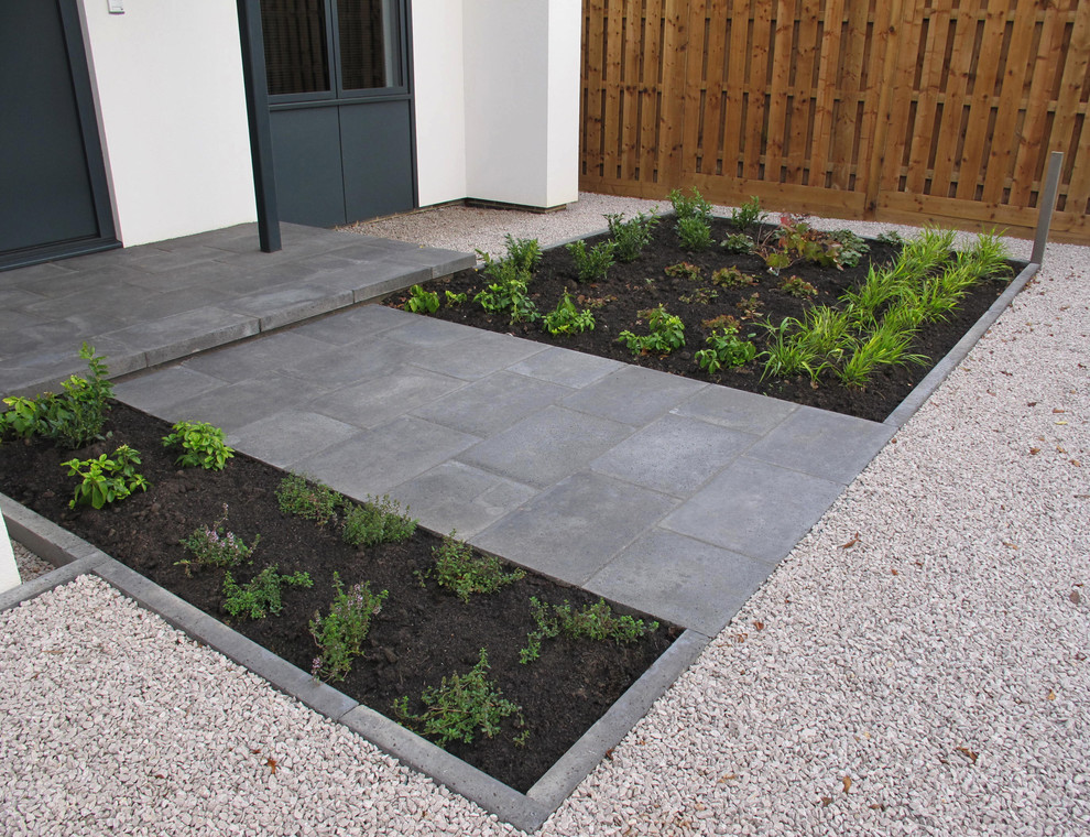 Design ideas for a medium sized contemporary front driveway partial sun garden in Other with a garden path and concrete paving.