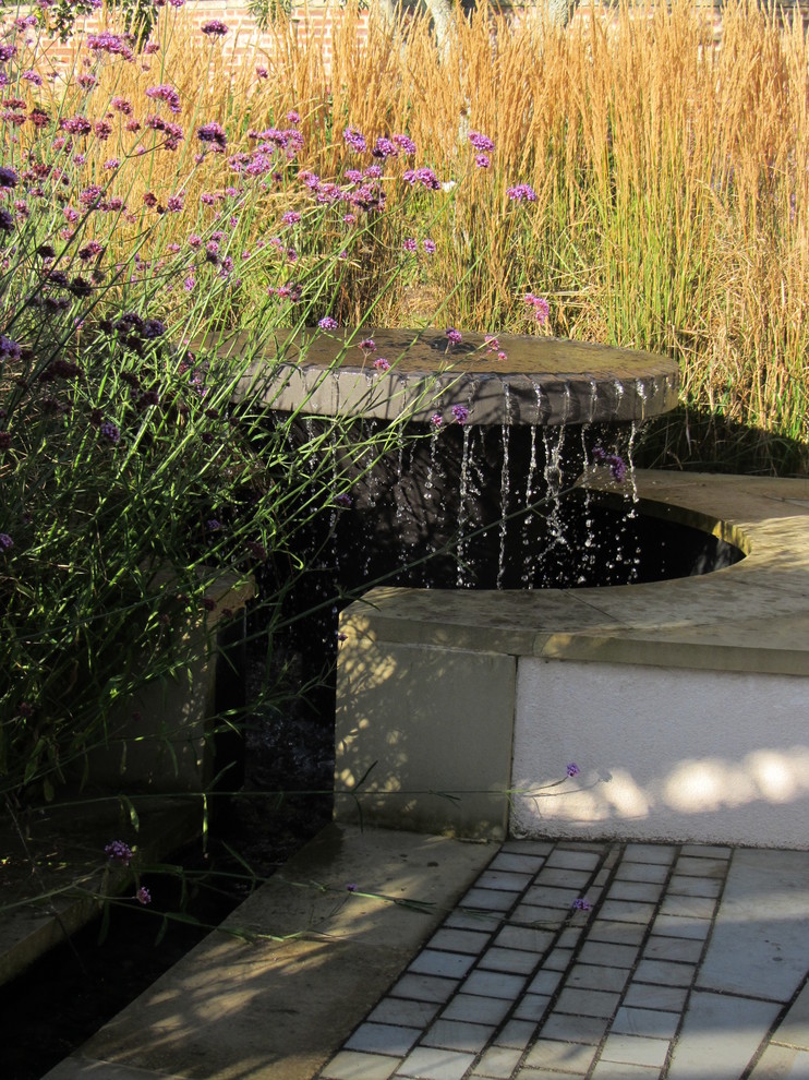 Idee per un grande giardino contemporaneo esposto in pieno sole dietro casa in estate con fontane e pavimentazioni in pietra naturale