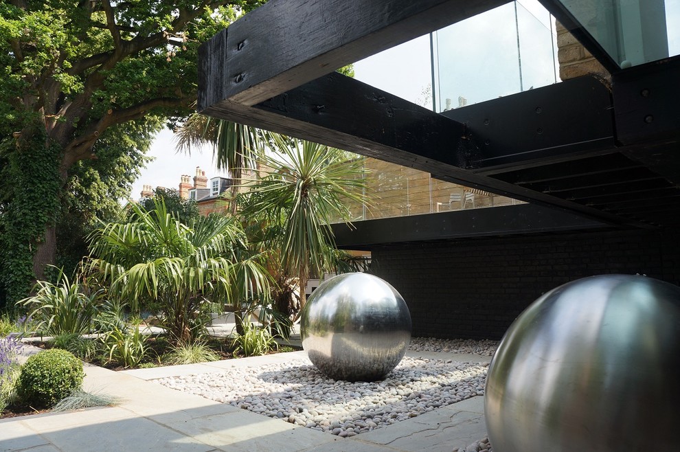 Geometrischer, Großer Moderner Garten hinter dem Haus mit direkter Sonneneinstrahlung und Natursteinplatten in London