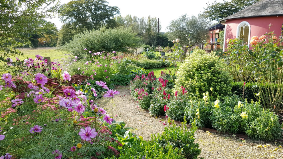Пример оригинального дизайна: участок и сад среднего размера в стиле кантри с клумбами