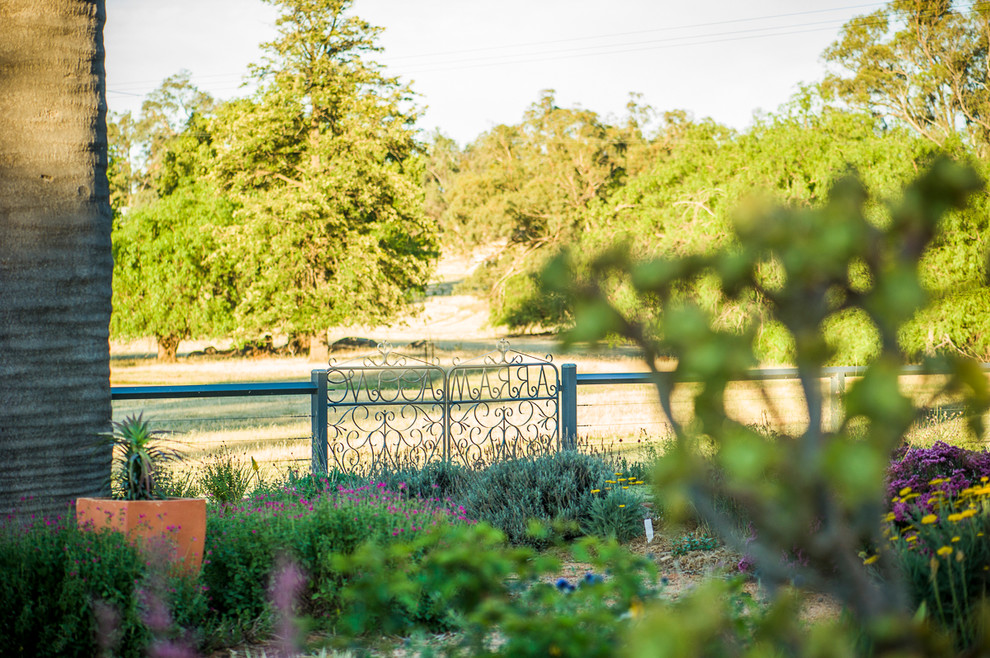 Immagine di un giardino country di medie dimensioni e dietro casa con ghiaia