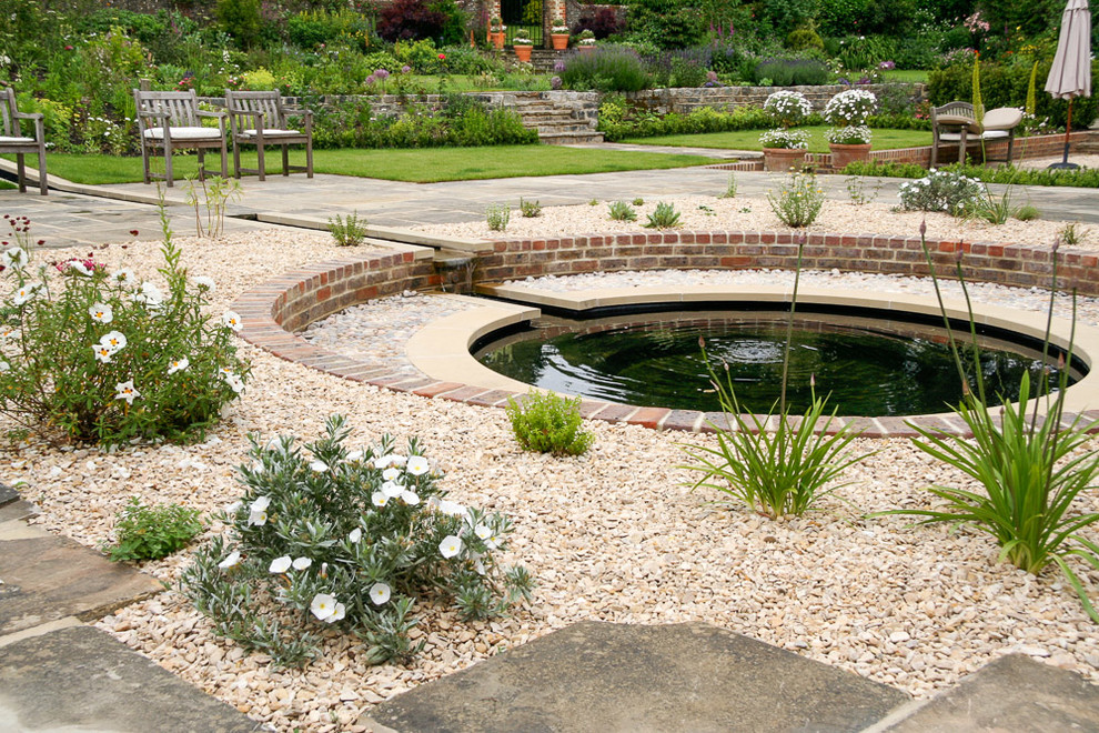 This is an example of a rural garden in Hampshire with a water feature.