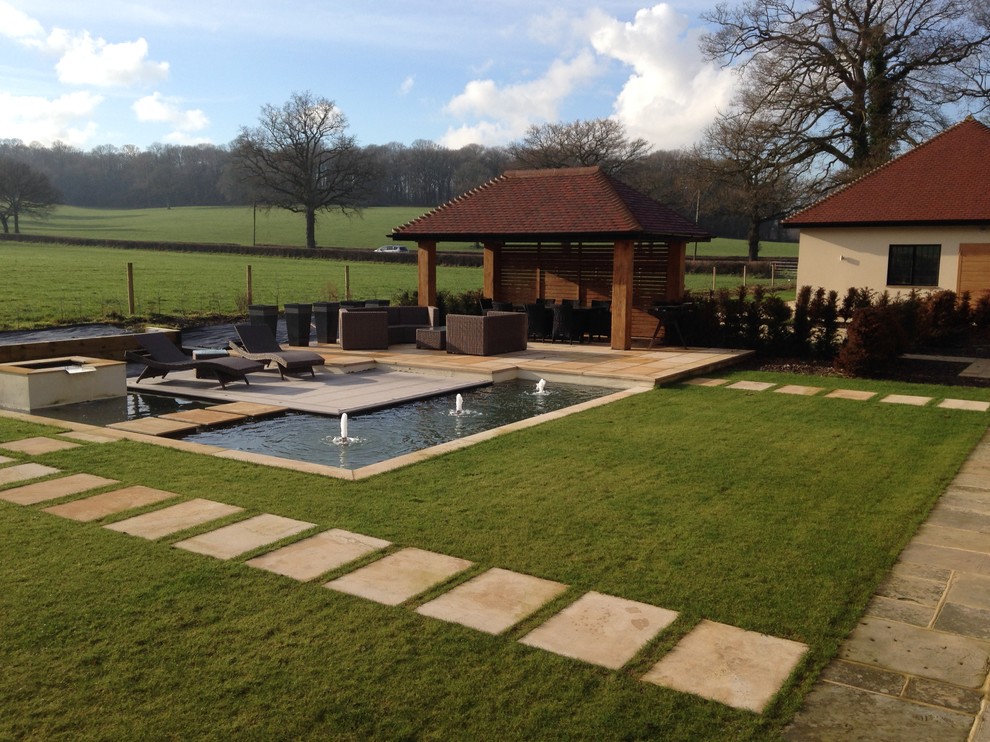 Large rural full sun garden in Sussex with a water feature.