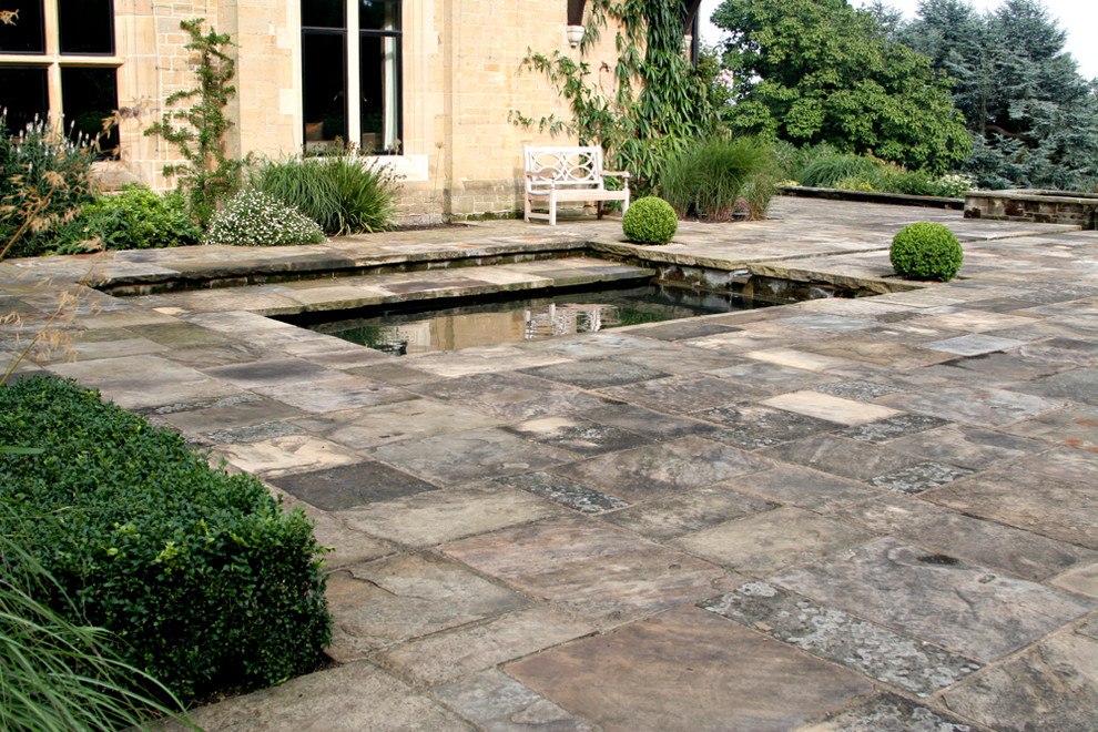 Photo of a rural garden in Hampshire with natural stone paving.