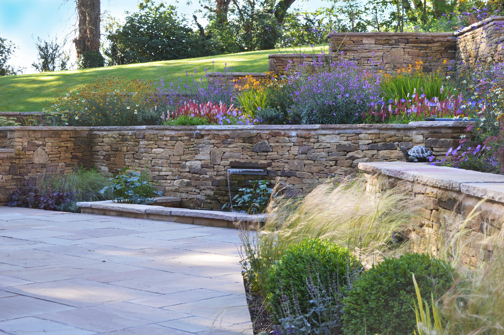 Идея дизайна: большой летний участок и сад на переднем дворе в классическом стиле с полуденной тенью и покрытием из каменной брусчатки