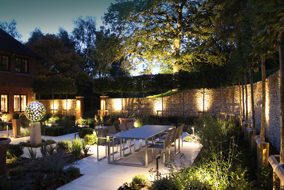 Foto di un giardino formale minimal esposto in pieno sole di medie dimensioni e in cortile in estate con un muro di contenimento e pavimentazioni in pietra naturale