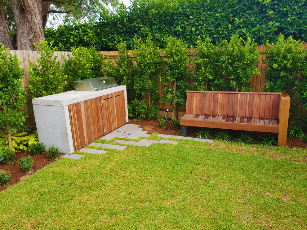 Cette image montre un petit jardin à la française arrière design l'été avec une exposition ensoleillée, des pavés en pierre naturelle et des solutions pour vis-à-vis.